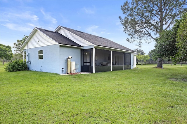 back of house with a yard and a sunroom