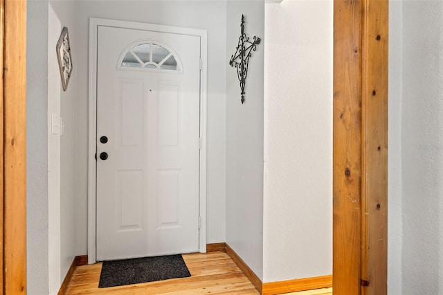 doorway to outside with light wood-style flooring and baseboards