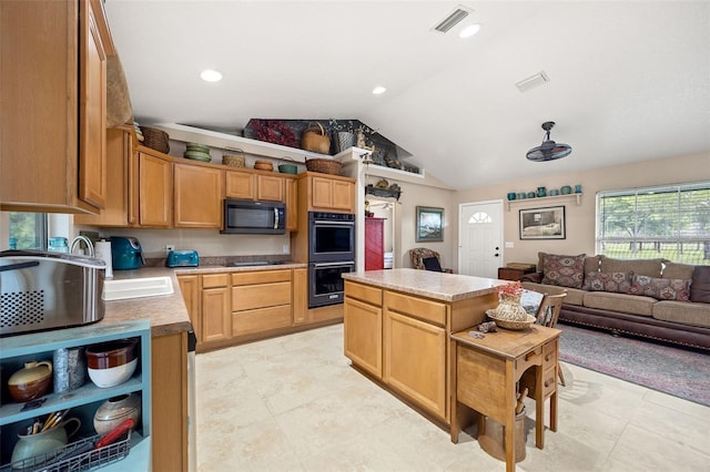 kitchen with a center island, visible vents, vaulted ceiling, and double wall oven