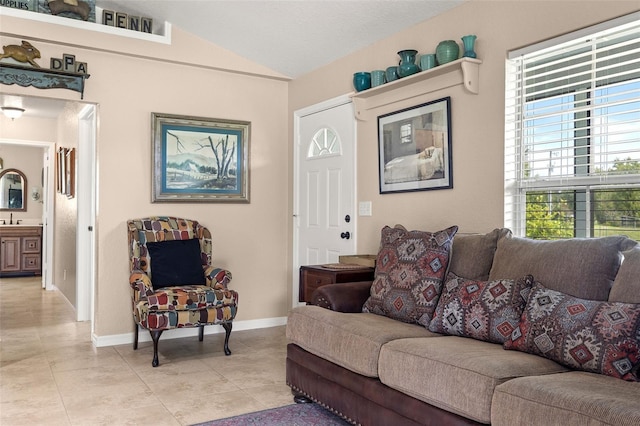 living room featuring lofted ceiling, baseboards, and light tile patterned floors