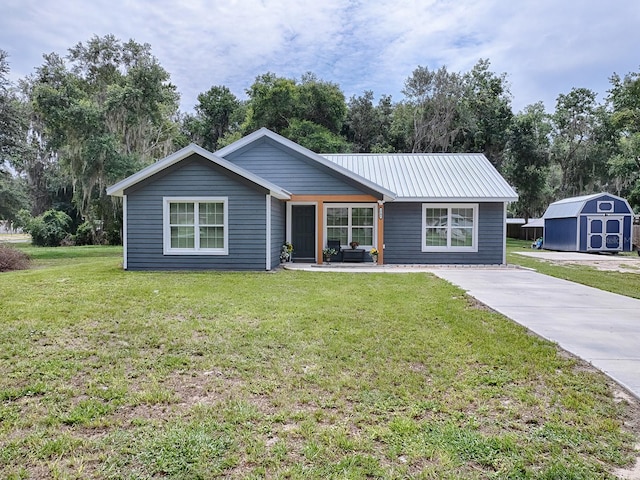 ranch-style home featuring a front lawn and a storage unit