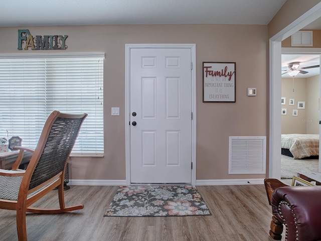 foyer with ceiling fan and light hardwood / wood-style floors