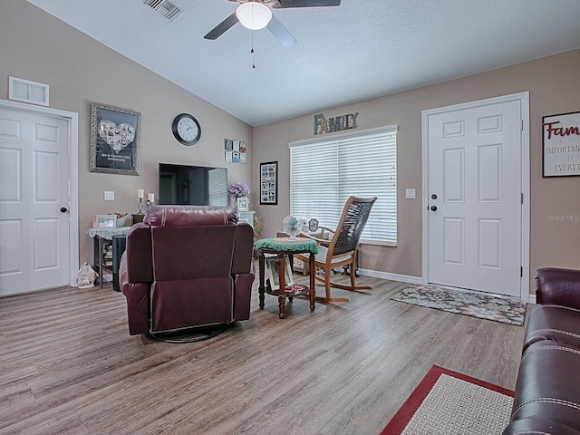 living room with ceiling fan, wood-type flooring, and lofted ceiling