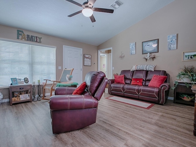 living room featuring ceiling fan, vaulted ceiling, and wood-type flooring