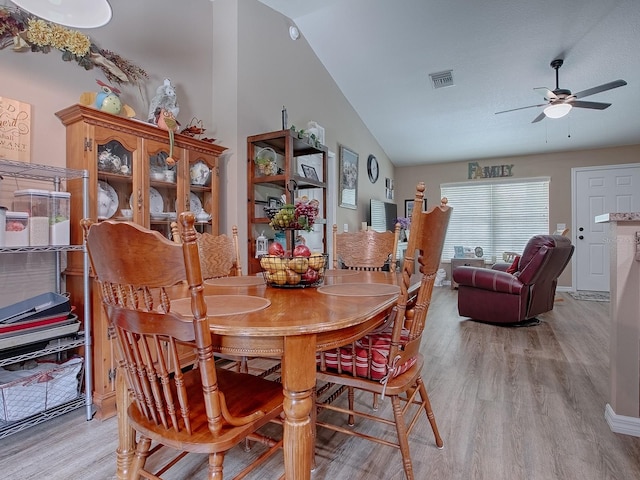 dining area featuring ceiling fan, light hardwood / wood-style flooring, and vaulted ceiling