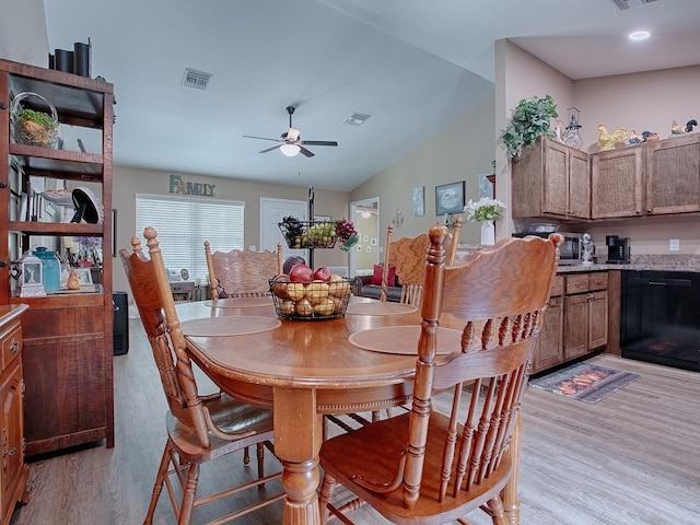 dining room with ceiling fan, lofted ceiling, and light hardwood / wood-style floors