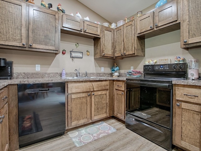 kitchen with black appliances, light hardwood / wood-style flooring, lofted ceiling, and sink