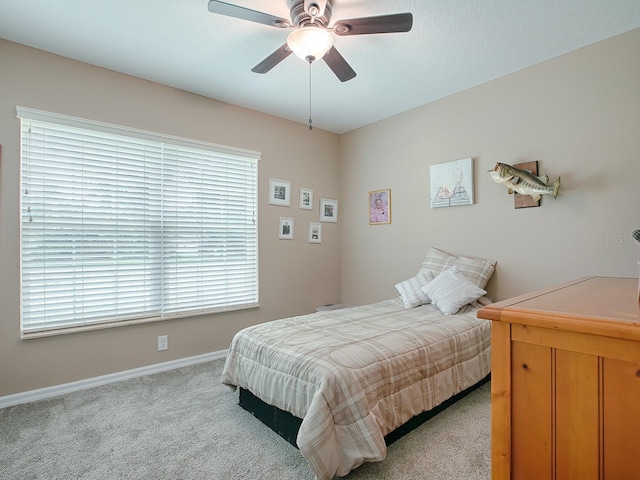 carpeted bedroom with ceiling fan and multiple windows