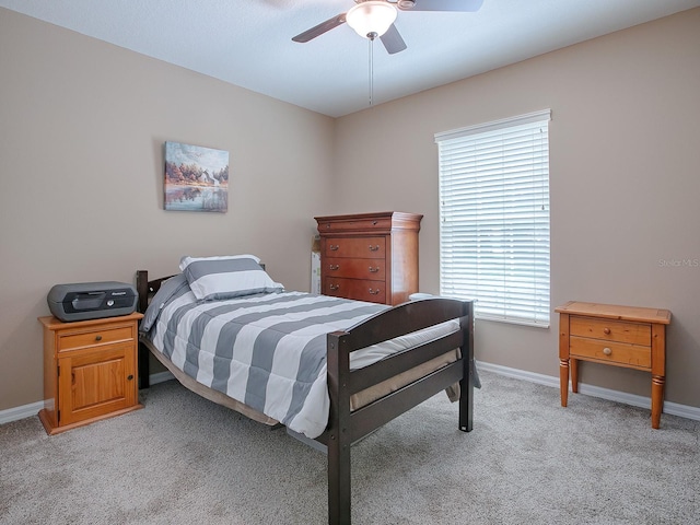 bedroom featuring light carpet, ceiling fan, and multiple windows