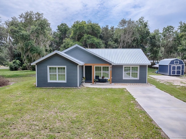 ranch-style home featuring a front lawn and a storage unit