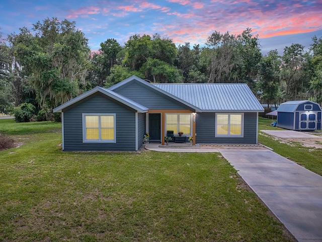 single story home featuring a shed and a yard