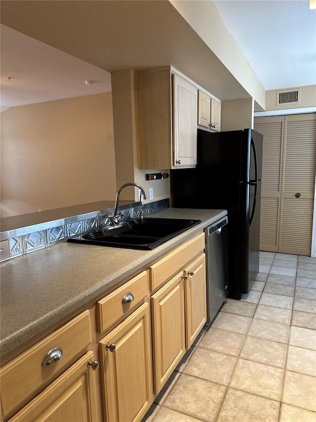 kitchen featuring light brown cabinetry, stainless steel dishwasher, sink, and light tile patterned floors