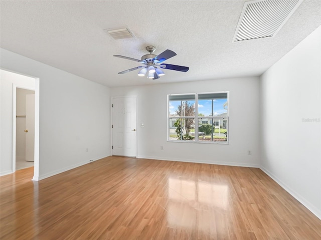 spare room featuring ceiling fan, a textured ceiling, and light hardwood / wood-style floors