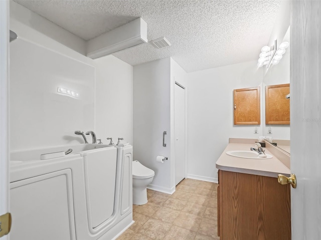 bathroom with a textured ceiling, toilet, vanity, and tile patterned floors