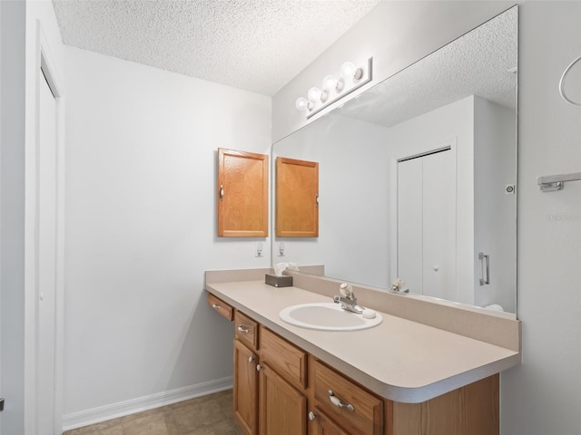 bathroom with tile patterned floors, a textured ceiling, and vanity