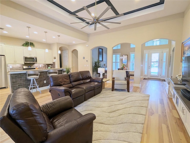 living room with light hardwood / wood-style flooring and ceiling fan