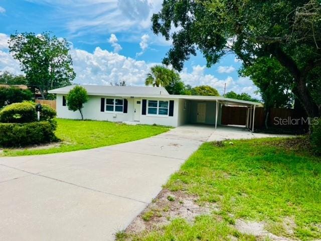 ranch-style home with a carport and a front yard