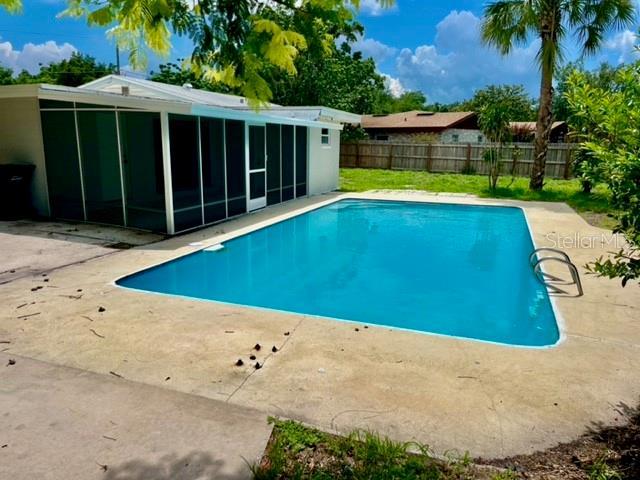 view of swimming pool with a patio and a sunroom