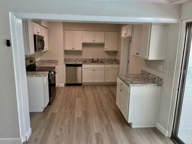 kitchen featuring white cabinets, stainless steel appliances, and light hardwood / wood-style floors