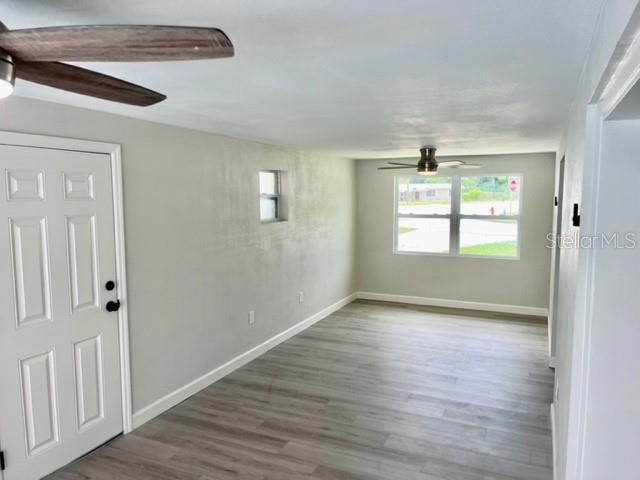 empty room with hardwood / wood-style floors and ceiling fan