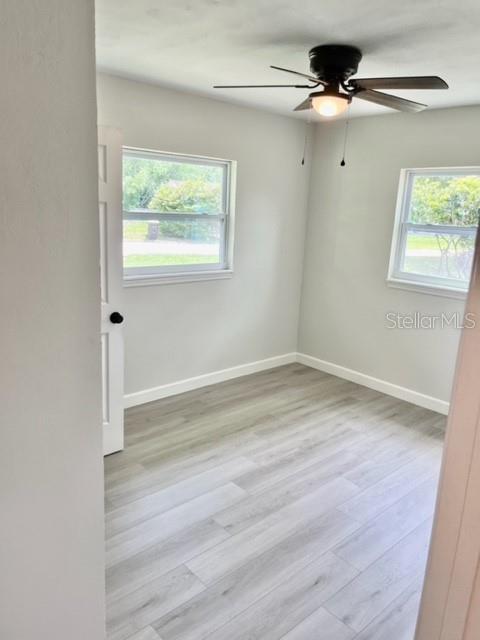 unfurnished room with ceiling fan and light wood-type flooring