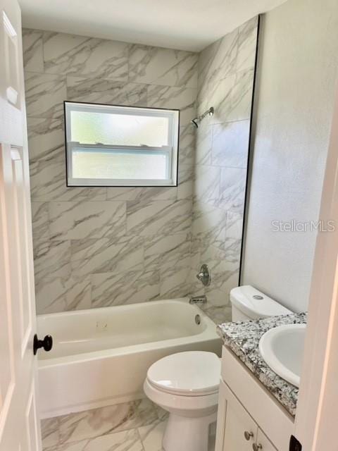 full bathroom with tile patterned floors, vanity, tiled shower / bath combo, and toilet