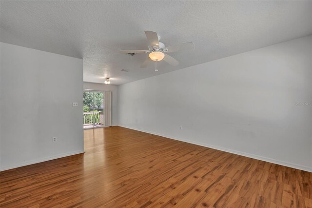 empty room with a textured ceiling, hardwood / wood-style floors, and ceiling fan