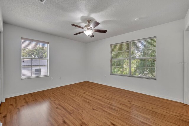 empty room with light hardwood / wood-style flooring, a textured ceiling, and ceiling fan