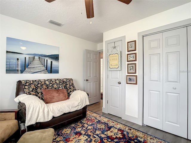 sitting room featuring ceiling fan, a textured ceiling, and hardwood / wood-style flooring