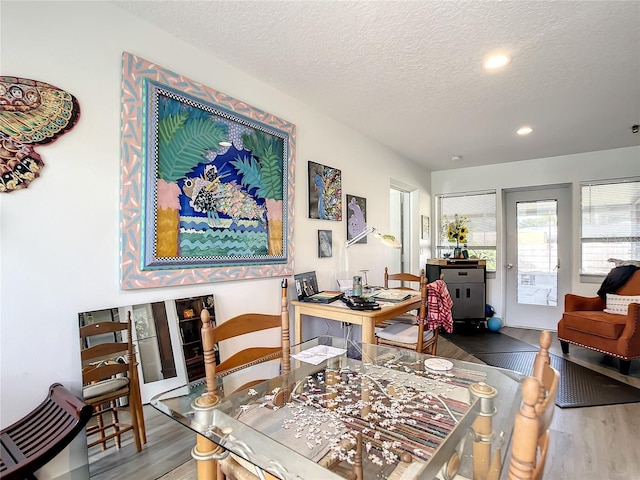 dining space featuring a textured ceiling and hardwood / wood-style flooring