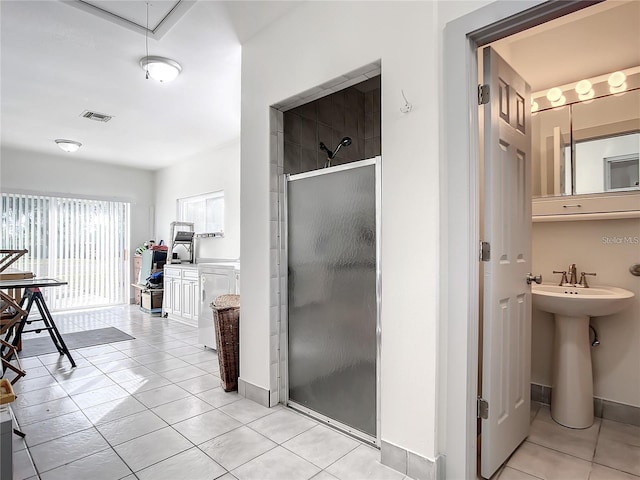 interior space featuring sink, washer / clothes dryer, and light tile patterned floors