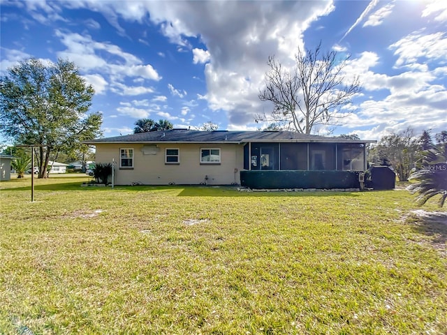 rear view of property with a sunroom and a yard