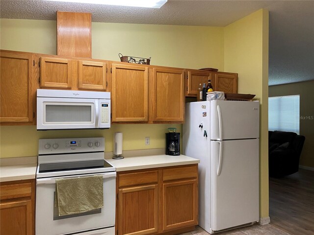 kitchen featuring white appliances, a textured ceiling, and light hardwood / wood-style flooring