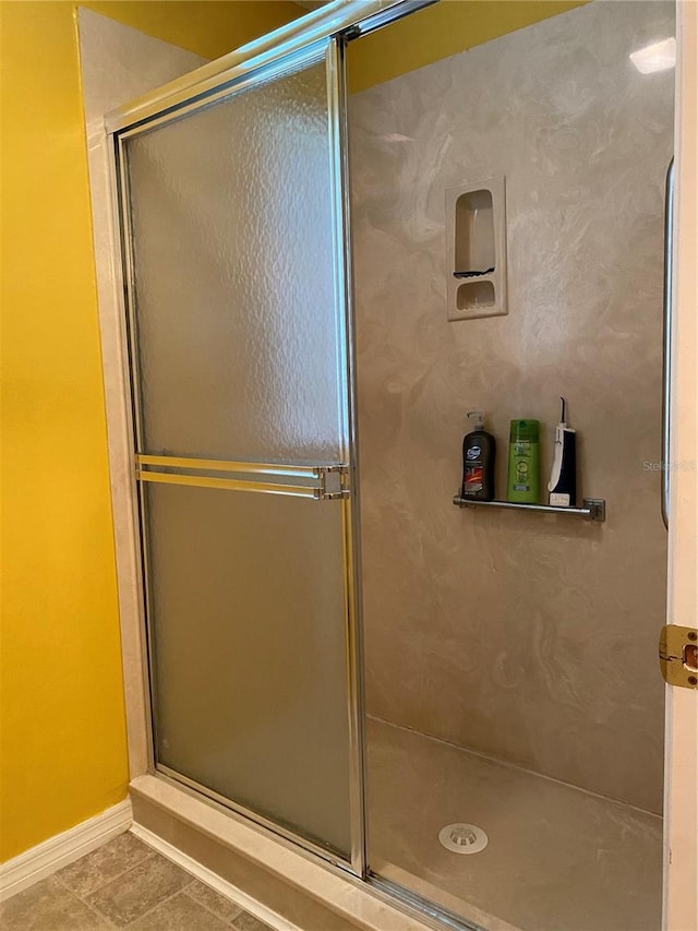 bathroom featuring tile patterned floors and a shower with shower door