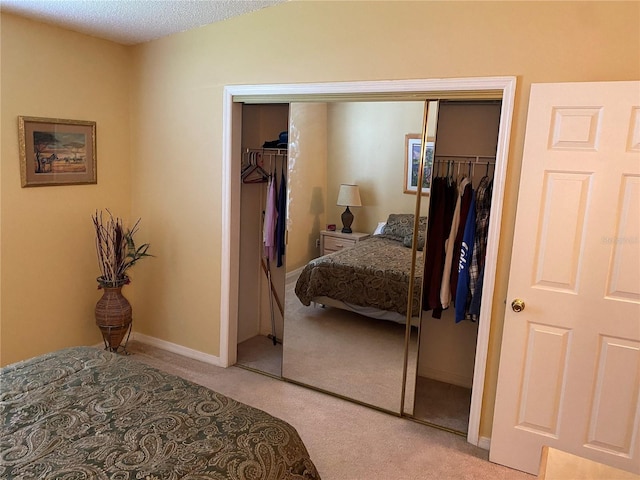 carpeted bedroom featuring a closet and a textured ceiling