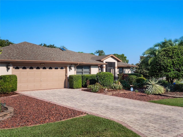 single story home with an attached garage, driveway, and stucco siding