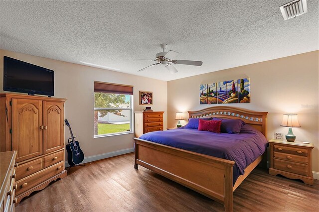 bedroom with ceiling fan, a textured ceiling, and hardwood / wood-style flooring