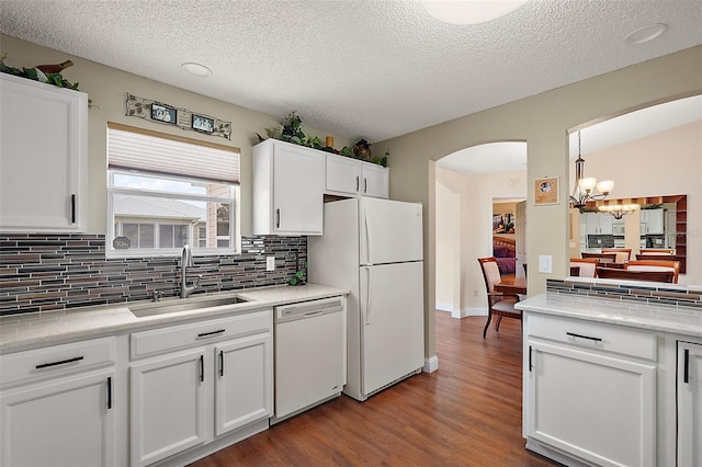 kitchen with white appliances, a chandelier, white cabinets, sink, and hardwood / wood-style floors