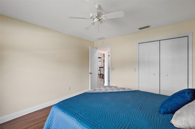 bedroom featuring ceiling fan, hardwood / wood-style flooring, a textured ceiling, and a closet