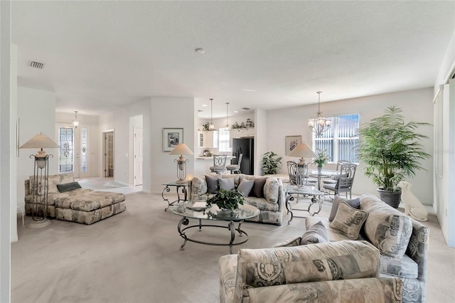 living room featuring an inviting chandelier, plenty of natural light, and light colored carpet