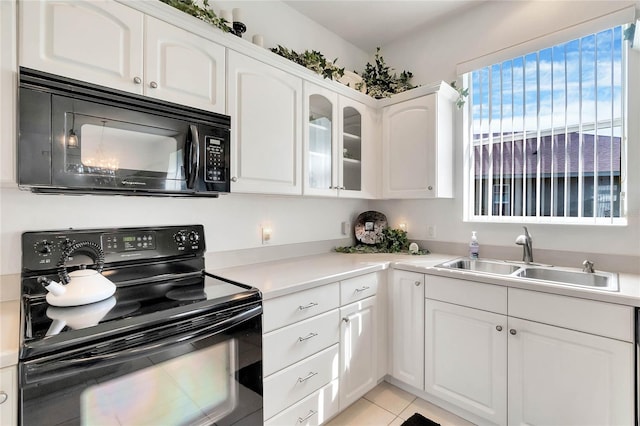 kitchen featuring white cabinets, light tile patterned floors, sink, and black appliances