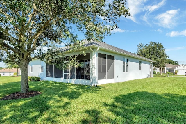 back of property featuring a lawn and a sunroom