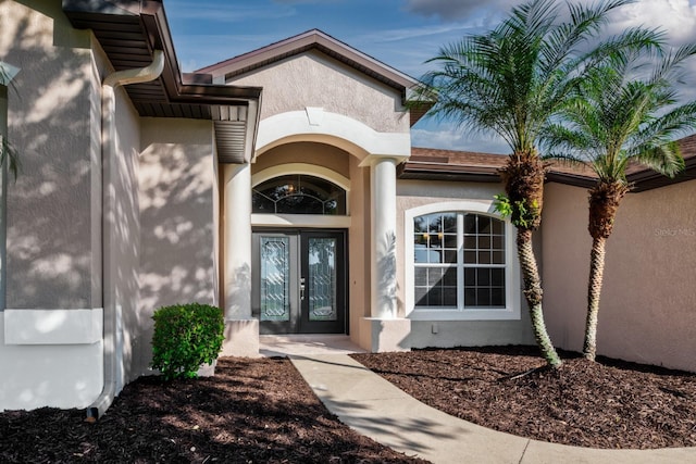 entrance to property with french doors and stucco siding