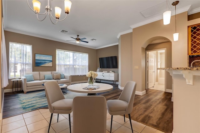 dining area featuring ceiling fan with notable chandelier, crown molding, and light hardwood / wood-style flooring