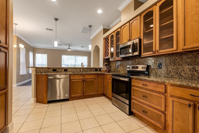 27303 Gingerbread Pl, Leesburg, FL 34748 - kitchen with appliances with stainless steel finishes, brown cabinets, a sink, backsplash, and crown molding