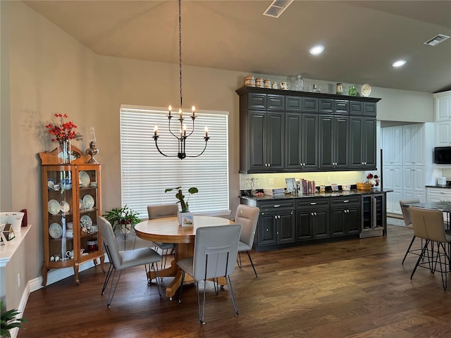 dining space with an inviting chandelier and dark hardwood / wood-style flooring