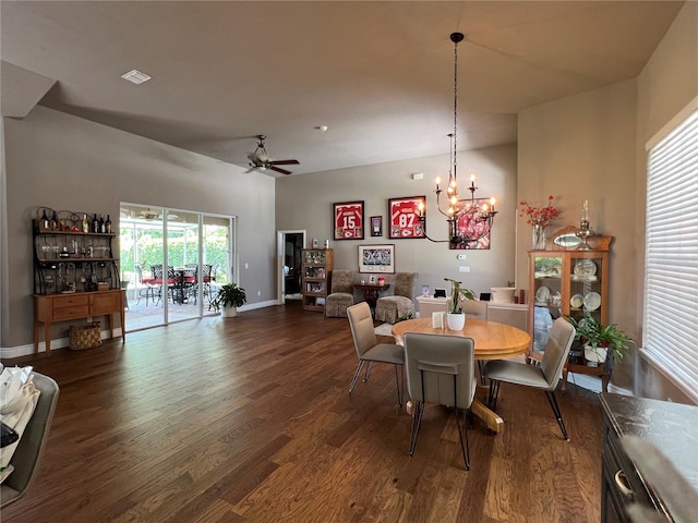 dining space featuring ceiling fan with notable chandelier and dark hardwood / wood-style floors