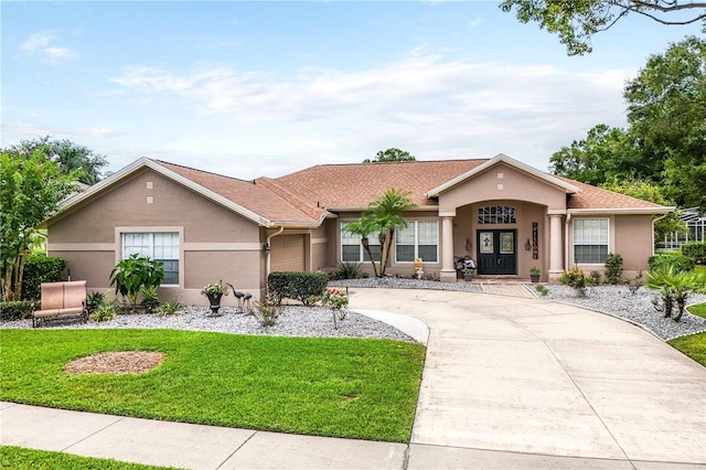 single story home featuring a garage and a front yard