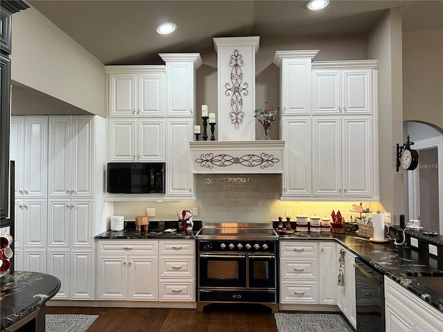 kitchen with dark wood-type flooring, dark stone counters, range with electric cooktop, and white cabinetry