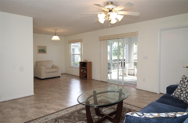 tiled living room with a textured ceiling and ceiling fan